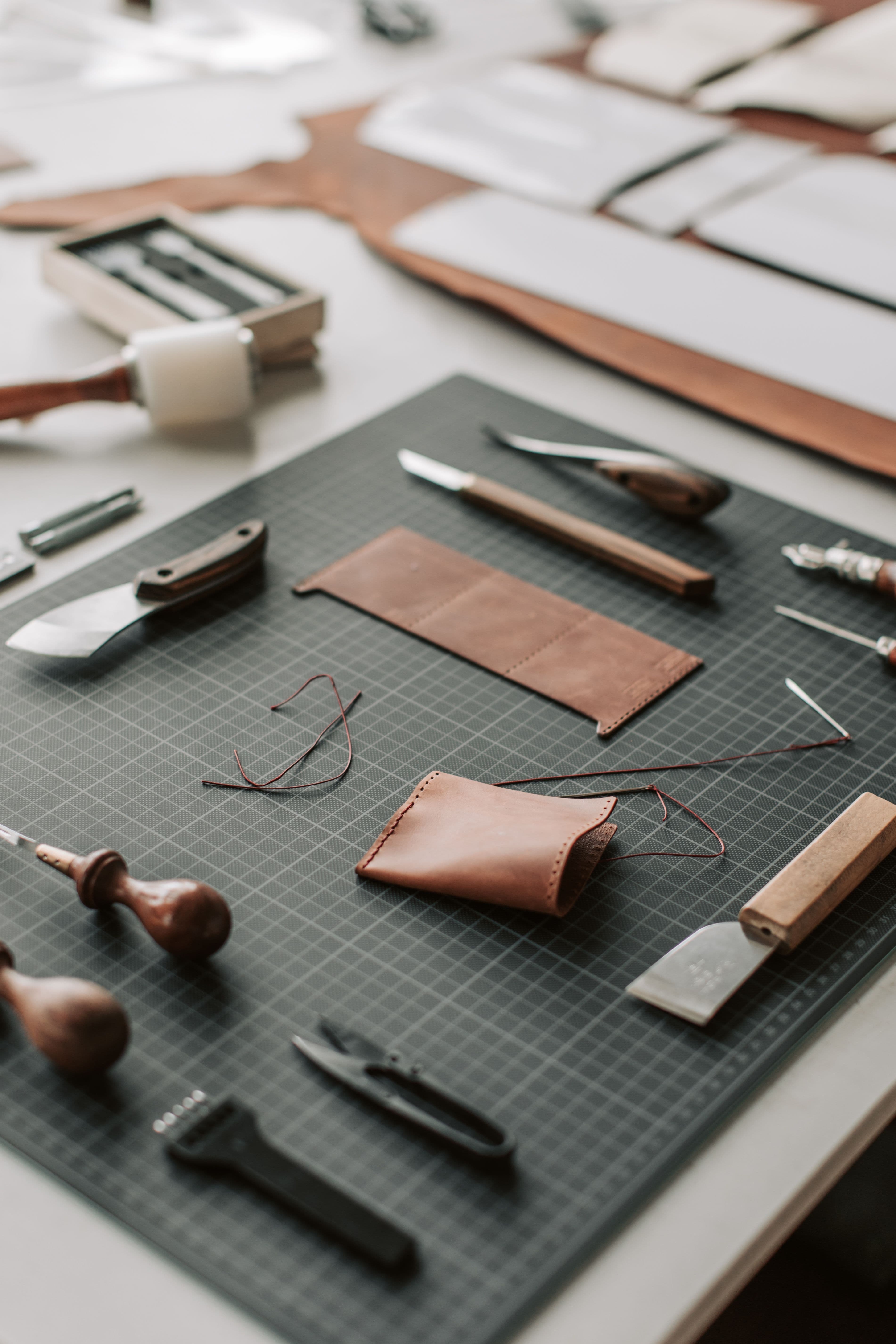 The leather workshop — tools and a hand-stitched piece